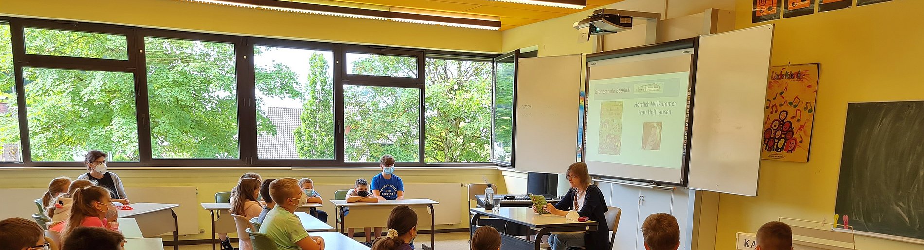Mit Mund-/Nasenschutz lauschten die Kinder der 4a der Autorin